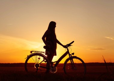 Günbatımında bir bisikletçi silüeti