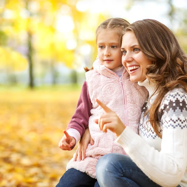 Mother and daughter having fun in the autumn park — Stock Photo, Image