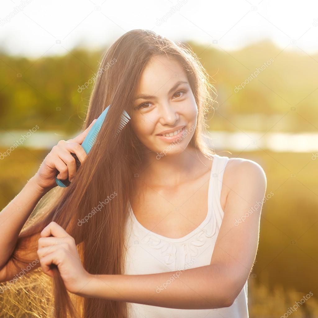 beautiful girl combs her hair Asian appearance