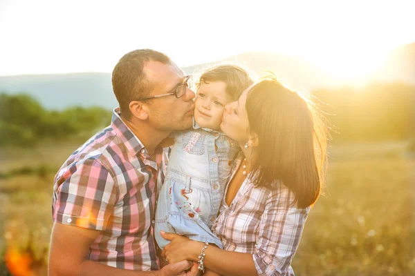 Feliz madre, padre e hija al atardecer — Foto de Stock