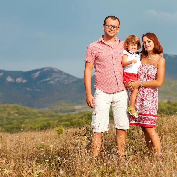 Lykkelig mor, far og datter ved solnedgang – stockfoto