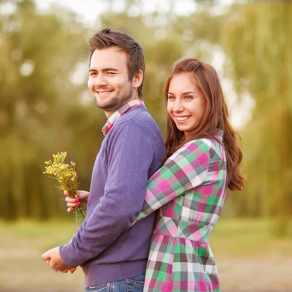 Pareja joven enamorada caminando en el parque de otoño cerca del río . — Foto de Stock