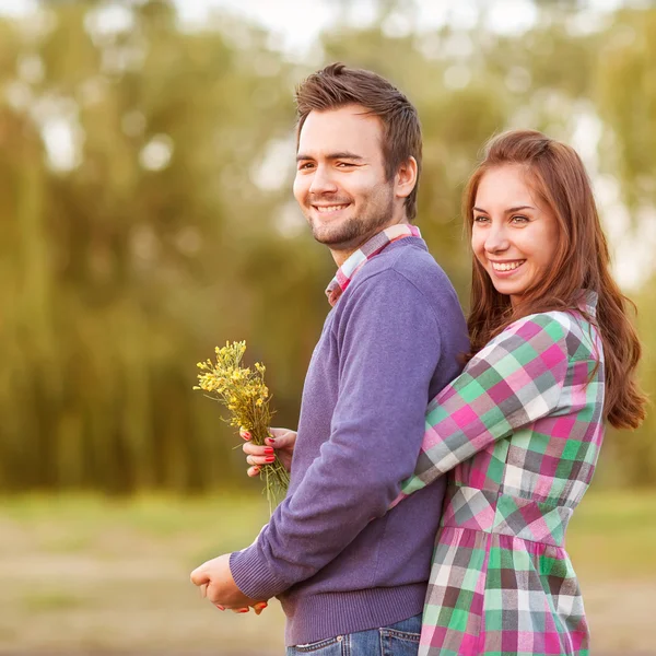 Jeune couple amoureux marchant dans le parc d'automne près de la rivière . — Photo