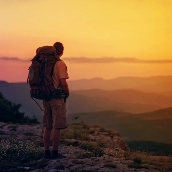 Kerel in de bergen bij zonsondergang. het concept van vrijheid — Stockfoto