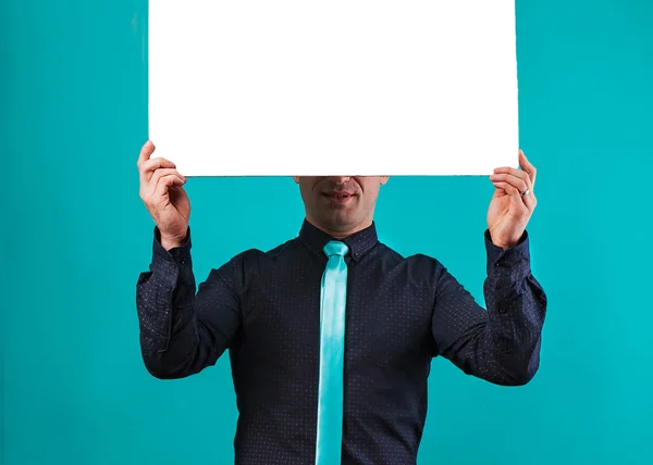 Primer plano de las manos del hombre mostrando tablero blanco en blanco — Foto de Stock