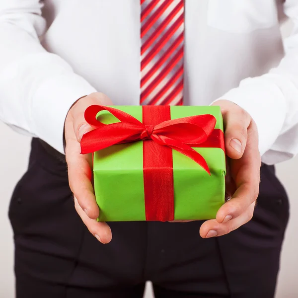 Geschäftsmann hält die Geschenkbox hin, isolierter Hintergrund — Stockfoto