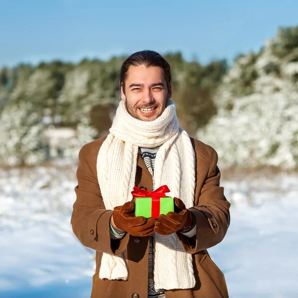 Man with gift waiting his woman in the woods in winter — Stock Photo, Image