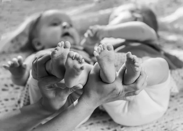 Nyfödd baby fötter på kvinnliga händer — Stockfoto