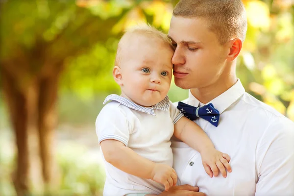 Šťastný mladý muž drží usmívající se dítě 7-9 měsíců — Stock fotografie
