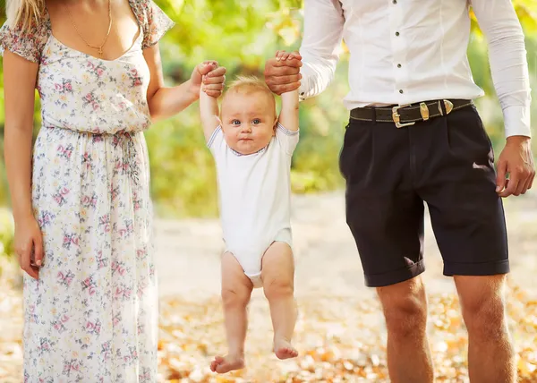 Feliz joven familia sosteniendo un sonriente bebé de 7-9 meses — Foto de Stock