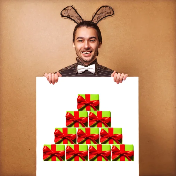 Fashion guy inbunny ears of holdingwhite board. Sale. — Stock Photo, Image