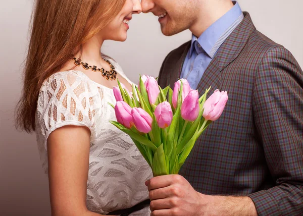 Couple in love with a bouquet of tulips are close to each other — Stock Photo, Image