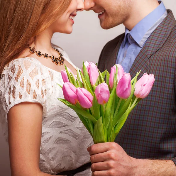 Couple in love with a bouquet of tulips are close to each other — Stock Photo, Image