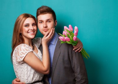 Lale buketi tutarak aşık genç bir çift.