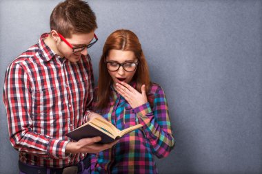 genç bir çift giysiler ve şık hipster gözlük bir kitap okuma.