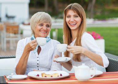 Yetişkin anne ve kızı içme çay veya kahve.