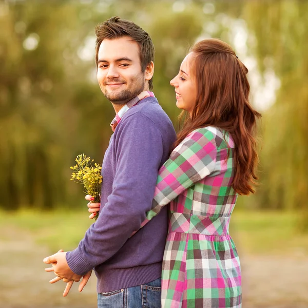 Jovem casal apaixonado andando no parque de outono perto do rio . — Fotografia de Stock