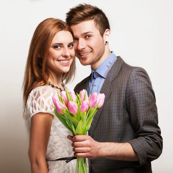 Jovem casal apaixonado segurando um buquê de tulipas . — Fotografia de Stock