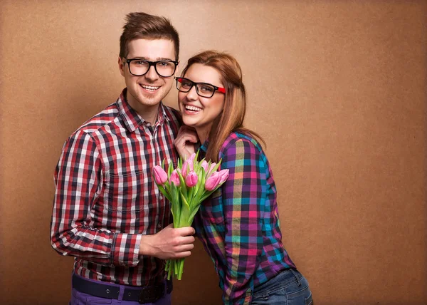 Pareja joven enamorada sosteniendo un ramo de tulipanes . — Foto de Stock