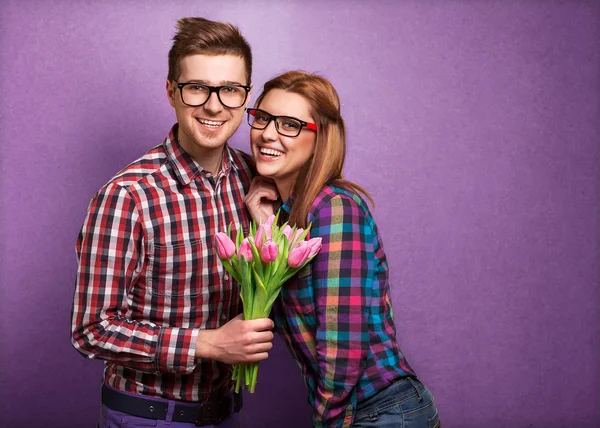 Pareja joven enamorada sosteniendo un ramo de tulipanes . —  Fotos de Stock