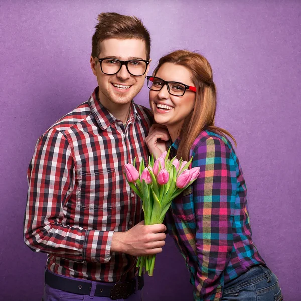 Pareja joven enamorada sosteniendo un ramo de tulipanes . — Foto de Stock