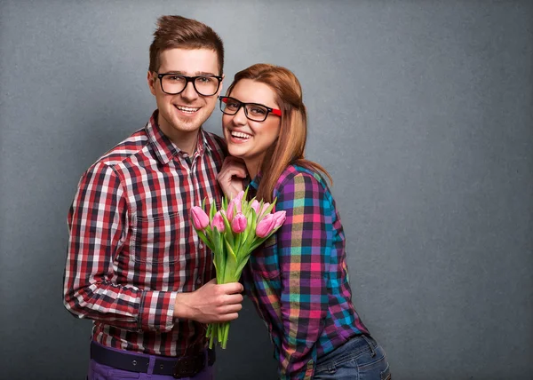 Pareja joven enamorada sosteniendo un ramo de tulipanes . — Foto de Stock