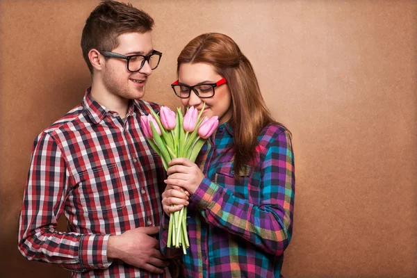 Retrato de pareja joven enamorada de flores tulipanes — Foto de Stock