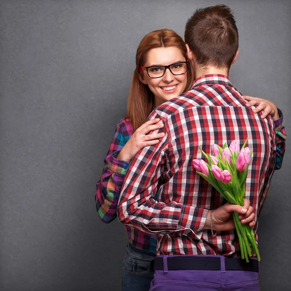 Pareja joven enamorada sosteniendo un ramo de tulipanes . —  Fotos de Stock