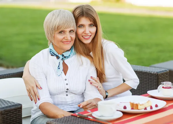 Madre adulta e hija tomando té o café y hablando al aire libre . — Foto de Stock