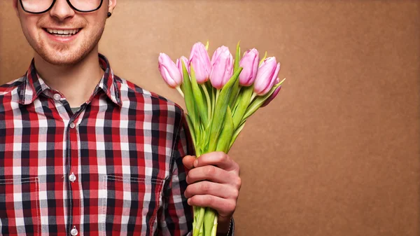 Homem hipster roupas segurando um buquê de flores — Fotografia de Stock