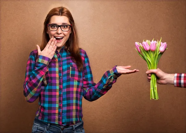 Flicka klädd i hipster förvånad donation av en bukett blommor — Stockfoto