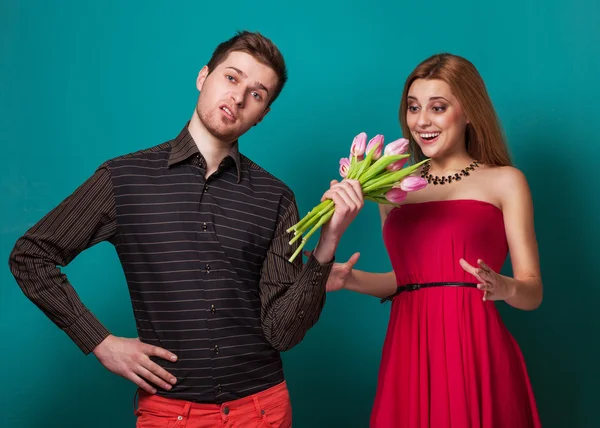 Jovem casal apaixonado segurando um buquê de tulipas . — Fotografia de Stock