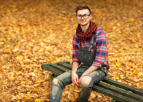 Joven hipster relajado hombre en la naturaleza, de vuelta en el árbol, prado detrás — Foto de Stock