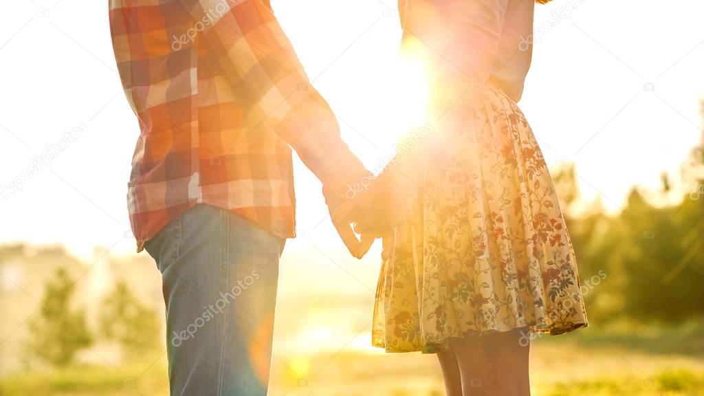 Young couple in love walking in the autumn park holding hands