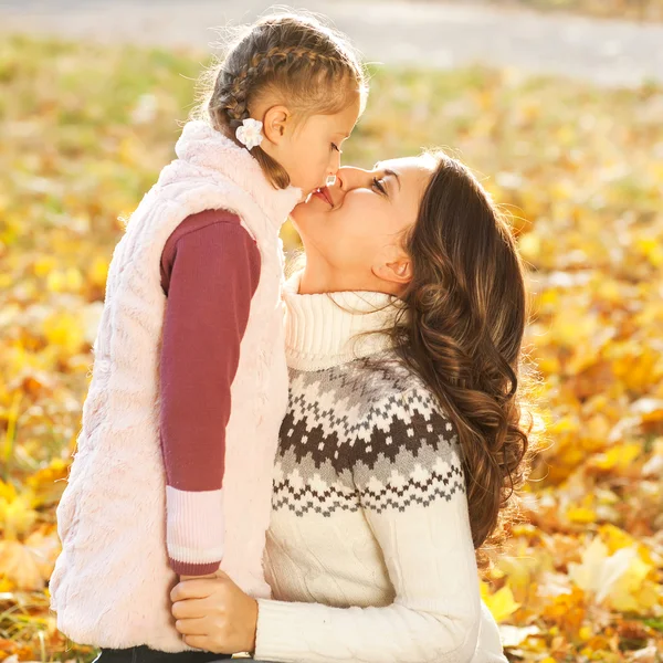 Mother and daughter having fun in the autumn park — Stock Photo, Image