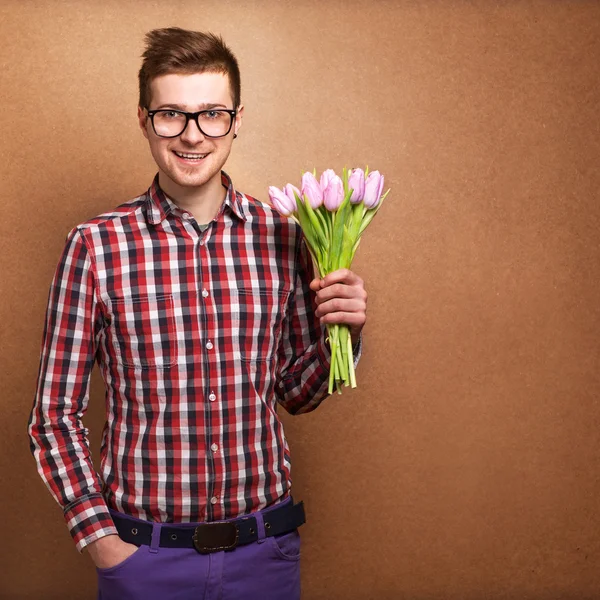 Um jovem homem romântico segurando um buquê de flores isolado no wh — Fotografia de Stock