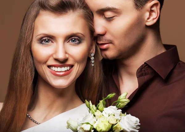 Couple in love with a bouquet of flowers are close to each other — Stock Photo, Image