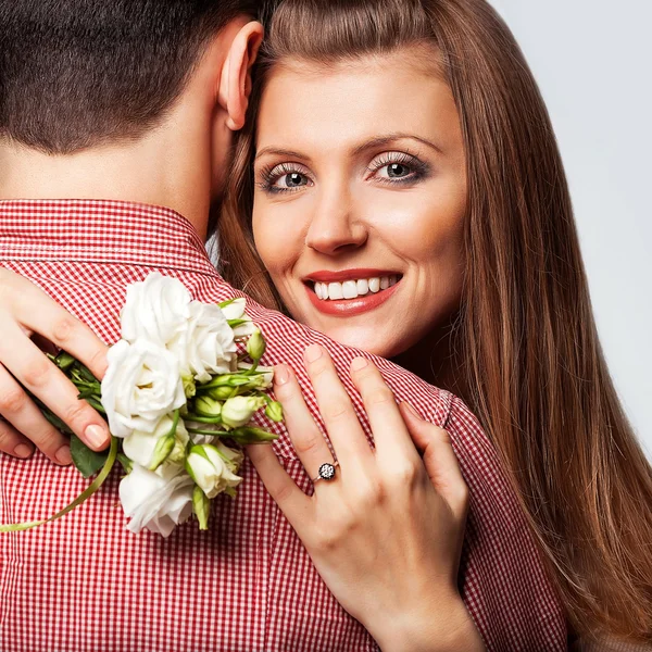 Couple amoureux font un cœur et les mains tiennent un bouquet — Photo