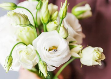  Yüzük kutusu ve bir buket çiçek tutan adam