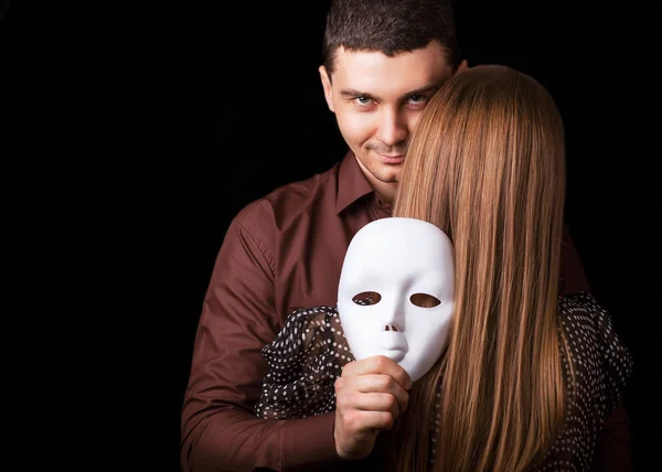 Moda Casal feliz no amor segurando um rosto de máscara branca . — Fotografia de Stock