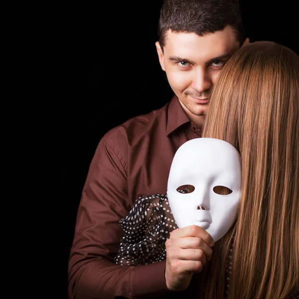 Fashion Happy Couple in Love holding a white mask face. — Stock Photo, Image