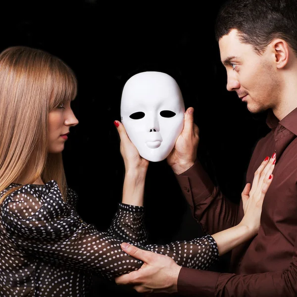 De gelukkige paar mode in liefde bedrijf een gezicht wit masker. — Stockfoto