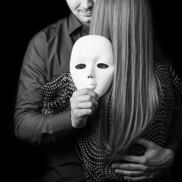 Fashion man holding a white mask face. Psychological concept. — Stock Photo, Image