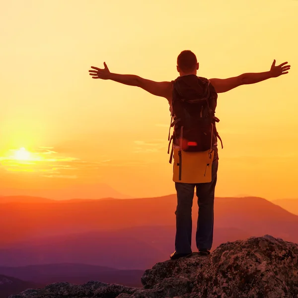 Un tizio in montagna al tramonto. il concetto di libertà — Foto Stock