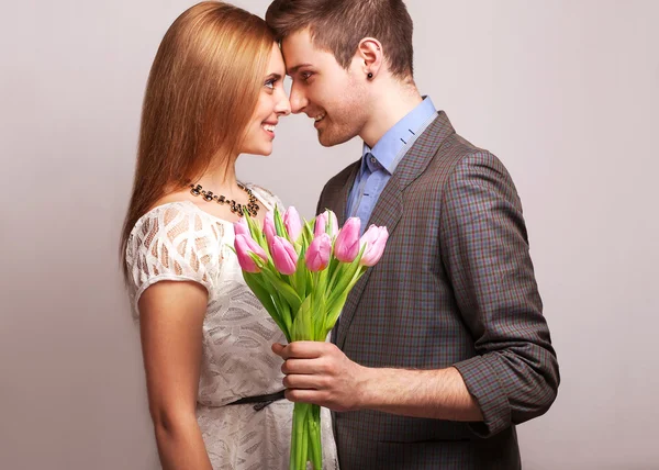 Couple in love with a bouquet of tulips are close to each other — Stock Photo, Image