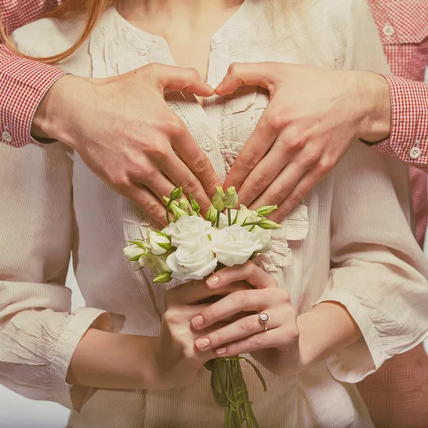 Pareja feliz enamorada mostrando el corazón con sus dedos —  Fotos de Stock