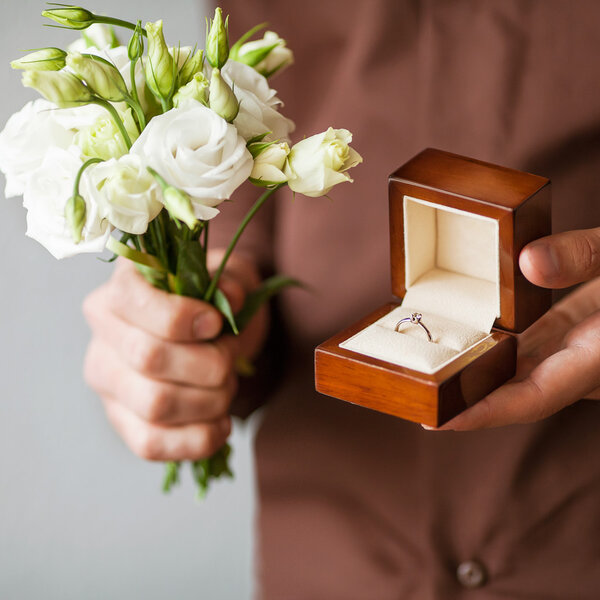 Happy man holding an engagement ring box