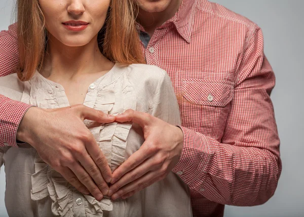 Jovem casal apaixonado fazer um coração e mãos — Fotografia de Stock