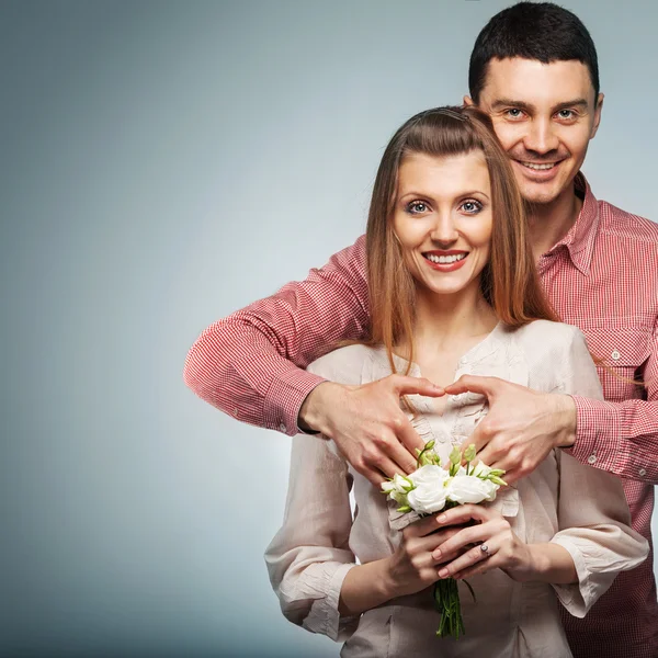 Young couple in love make a heart and hands — Stock Photo, Image