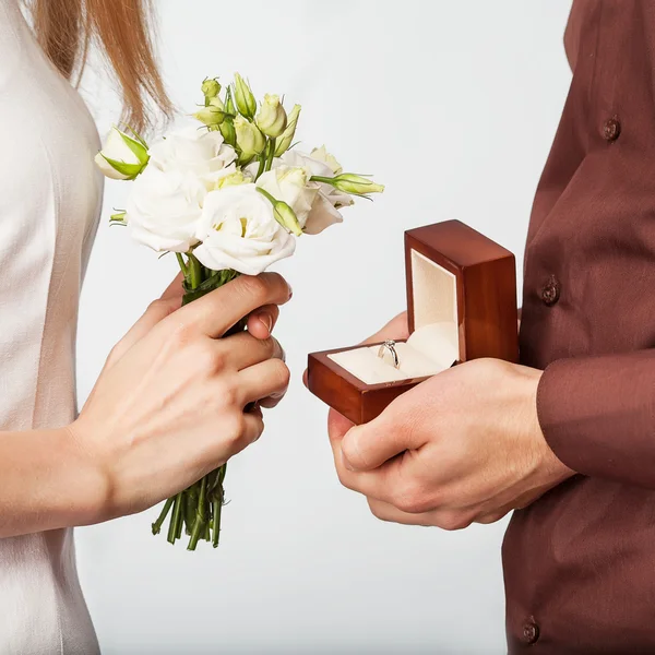 Couple de mariage tenant boîte à bague et un bouquet de fleurs — Photo